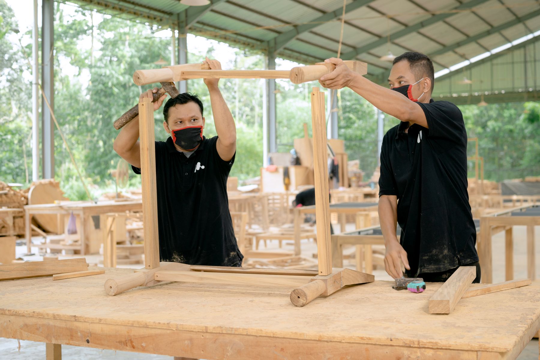 Carpenters assembling a custom wood storage frame in a workshop