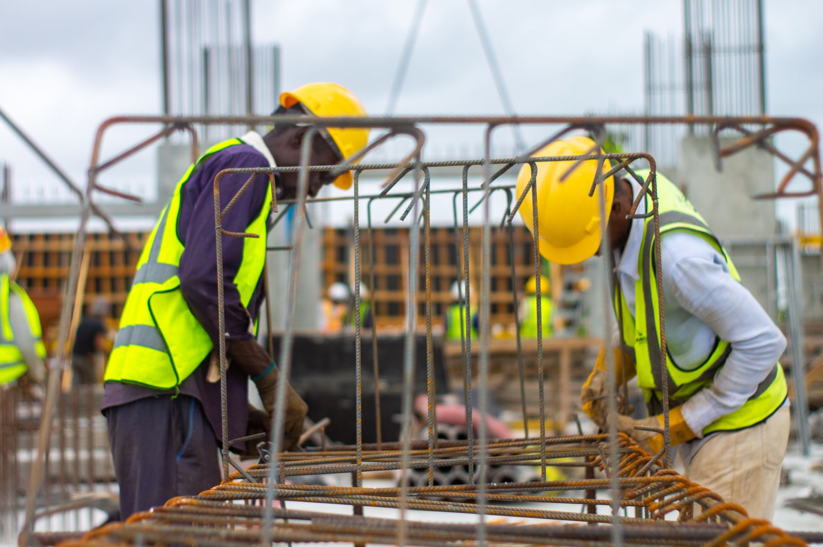 Construction crew assembling reinforcing steel on a concrete site