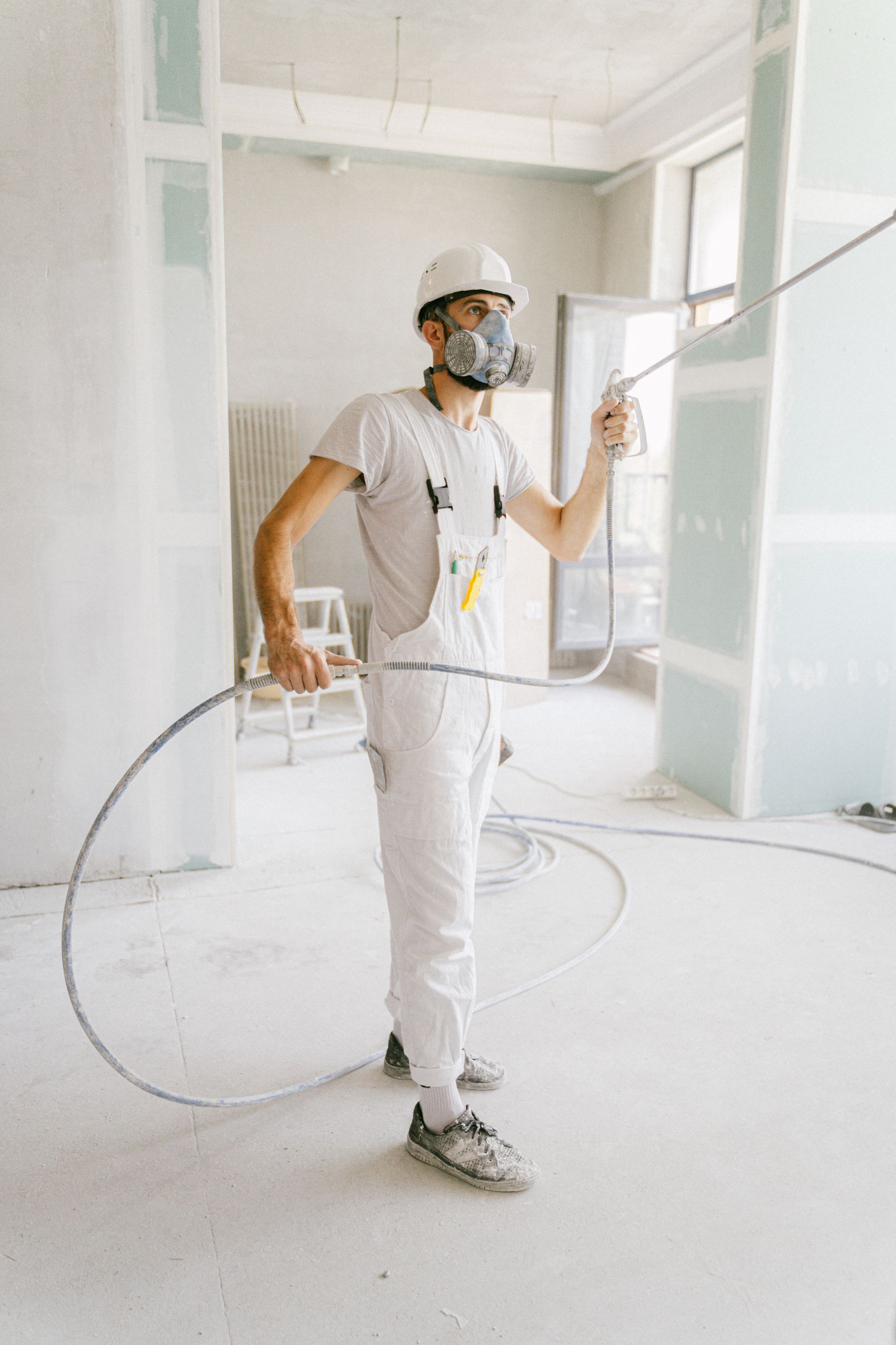 Protective contractor spraying interior surfaces during restoration work